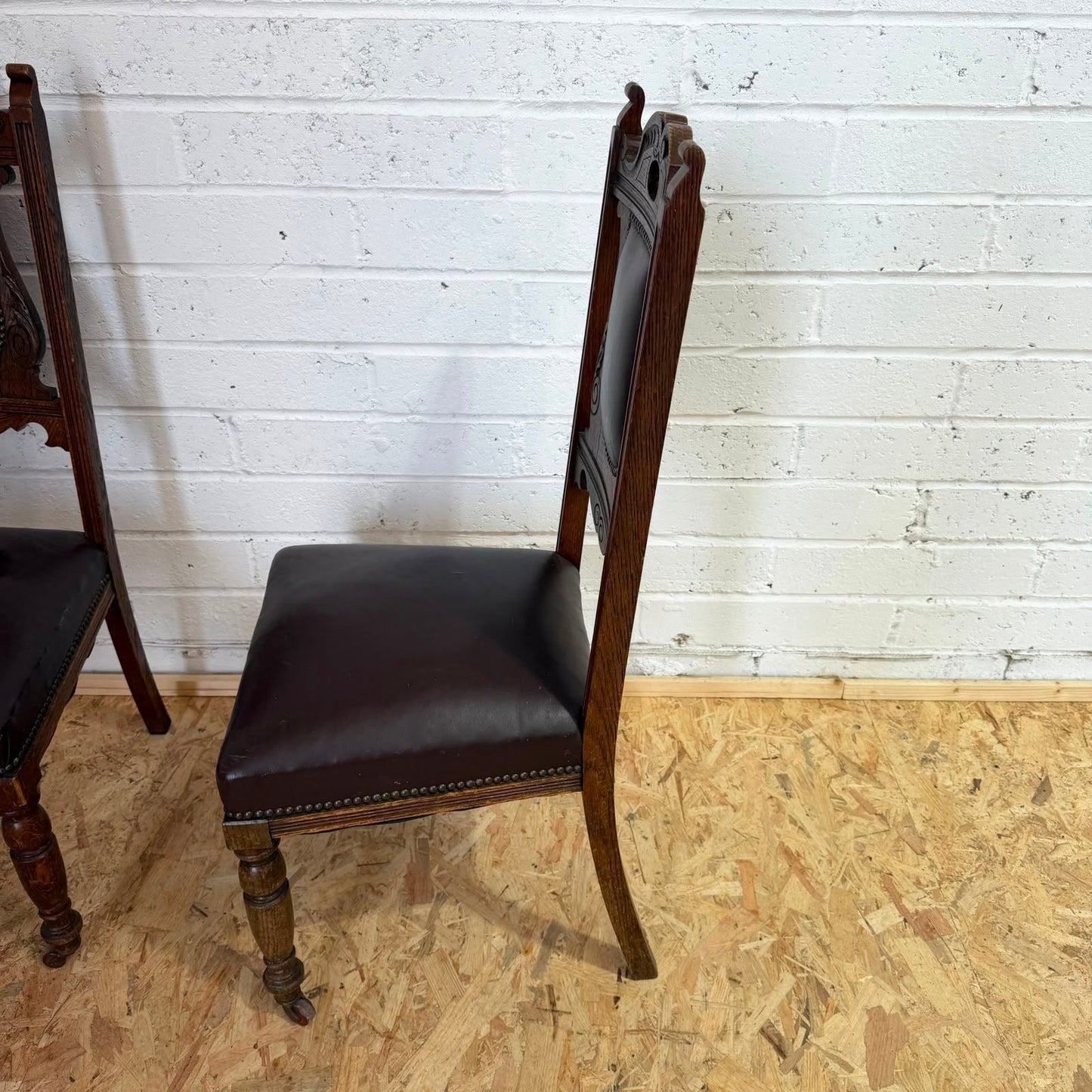 Pair Edwardian? Jacobean Style Dining Chairs Leather Seats Carved Backs Castors